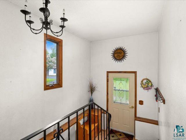 3616 Lavaque Road Hermantown, MN 55811 - Photo 34 of 43 Entryway featuring a decorative transom window, wood-finish flooring, and a wrought iron banister