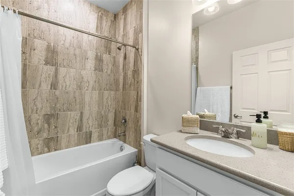 a bathroom with a granite countertop sink toilet and bathtub