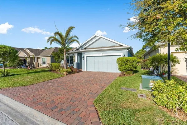 a front view of a house with a garden and plants