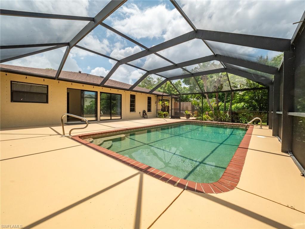 18414 Tulip Road Fort Myers, FL 33967 - Photo 32 of 37 Screen-enclosed swimming pool with a brick coping, surrounded by a spacious deck