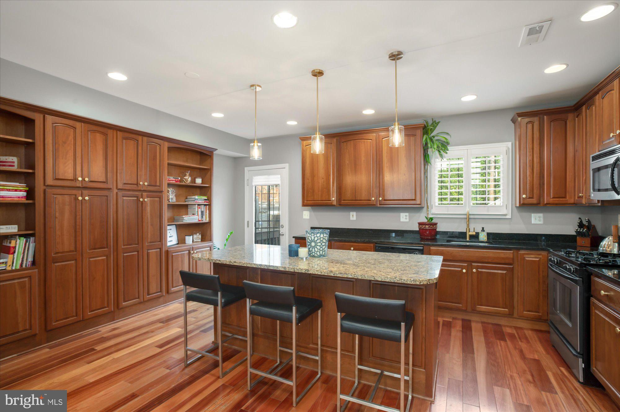 323 T Street Northwest Washington, DC 20001 - Photo 8 of 35 a kitchen with stainless steel appliances granite countertop a table chairs sink refrigerator and cabinets