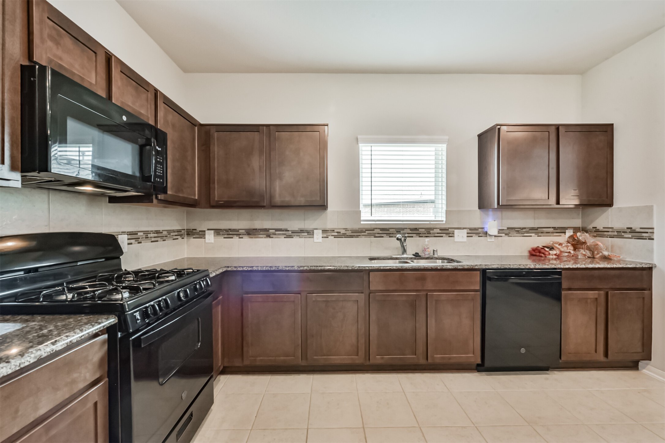 3607 Crosspointe Pass Angleton, TX 77515 - Photo 14 of 46 a kitchen with stainless steel appliances granite countertop a sink stove microwave and cabinets