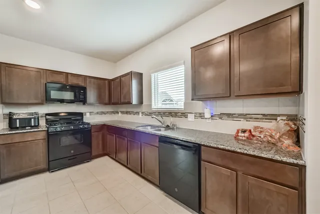 a kitchen with stainless steel appliances granite countertop a sink stove and microwave