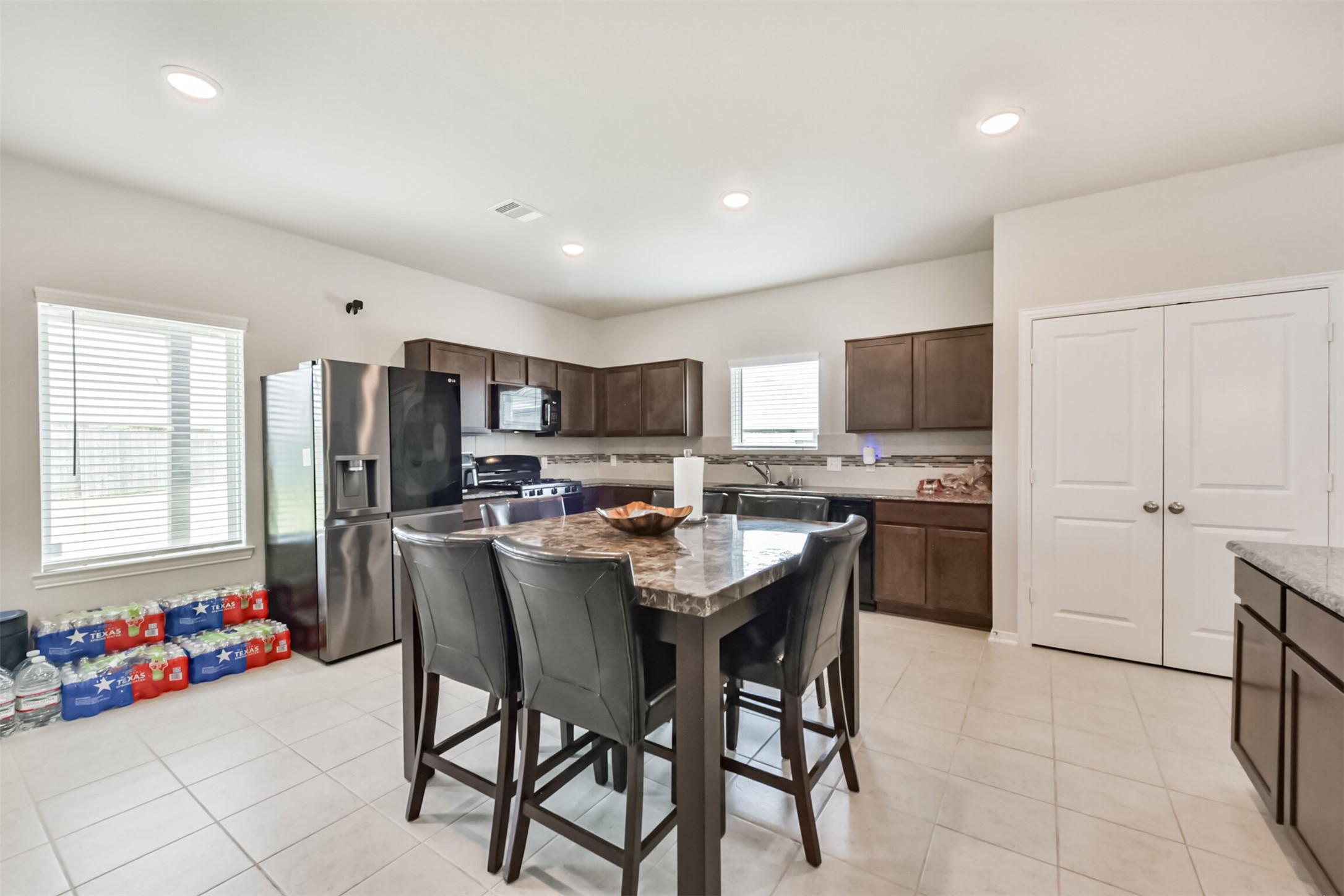 3607 Crosspointe Pass Angleton, TX 77515 - Photo 18 of 46 a kitchen with a refrigerator and a dining table