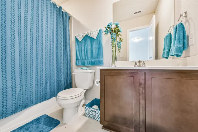 a spacious bedroom with a bed and a dresser in it