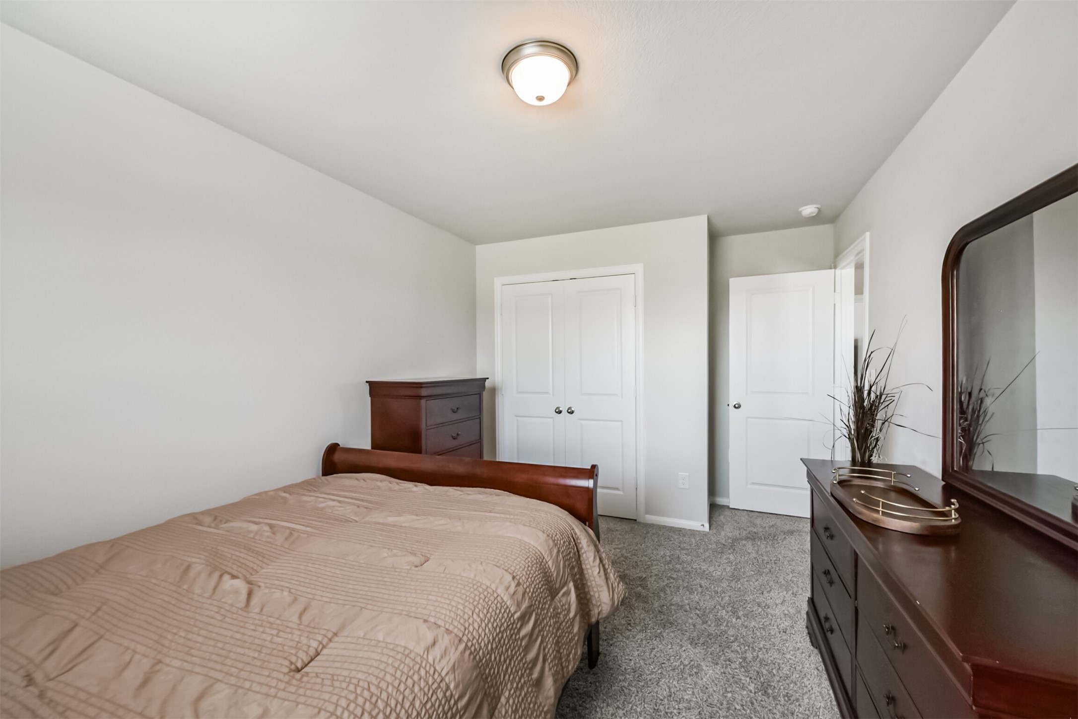 3607 Crosspointe Pass Angleton, TX 77515 - Photo 32 of 46 a bedroom with a bed and a dresser with mirror
