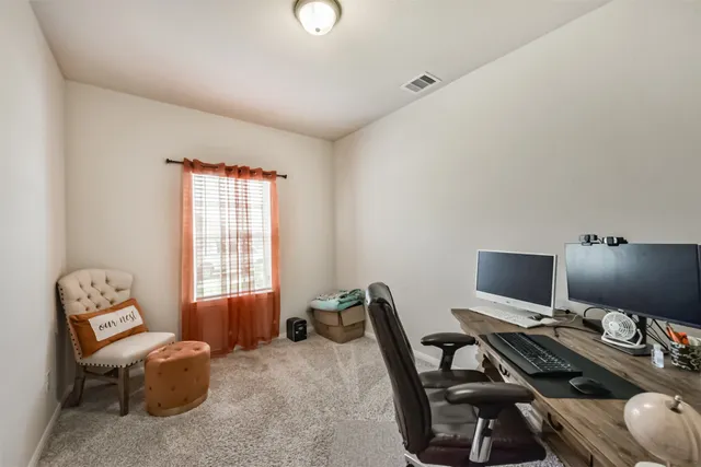 a view of a workspace with furniture and a window