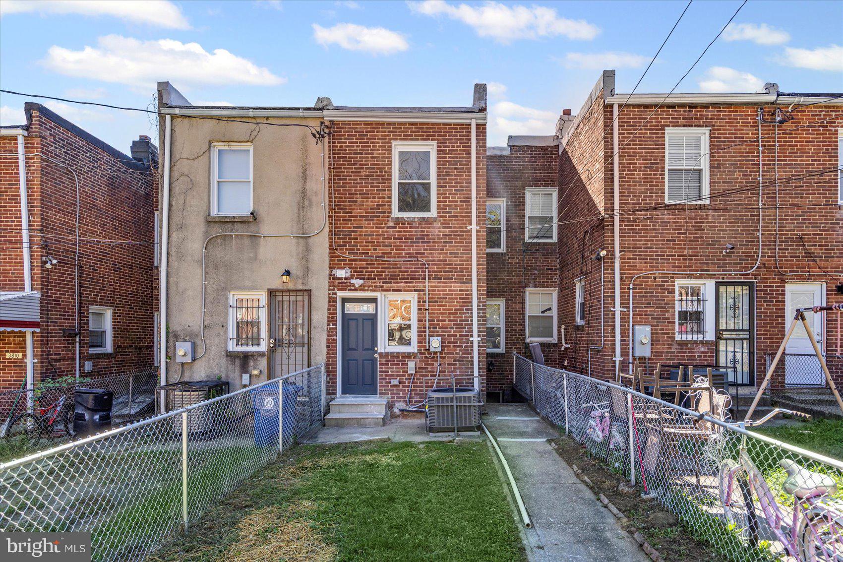 3814 Flowerton Road Baltimore, MD 21229 - Photo 36 of 42 a view of a brick house with many windows and a yard