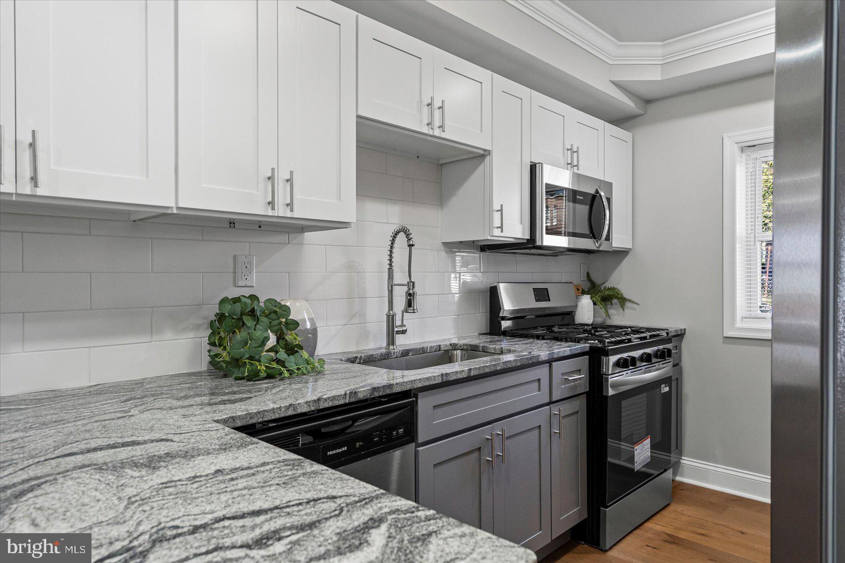 3814 Flowerton Road Baltimore, MD 21229 - Photo 9 of 42 a kitchen with stainless steel appliances granite countertop a stove a sink and a microwave