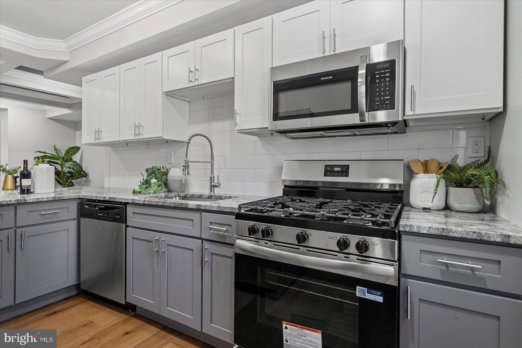 3814 Flowerton Road Baltimore, MD 21229 - Photo 10 of 42 a kitchen with stainless steel appliances granite countertop a stove a microwave a sink and cabinets