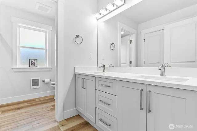 a bathroom with double vanity sink and a mirror