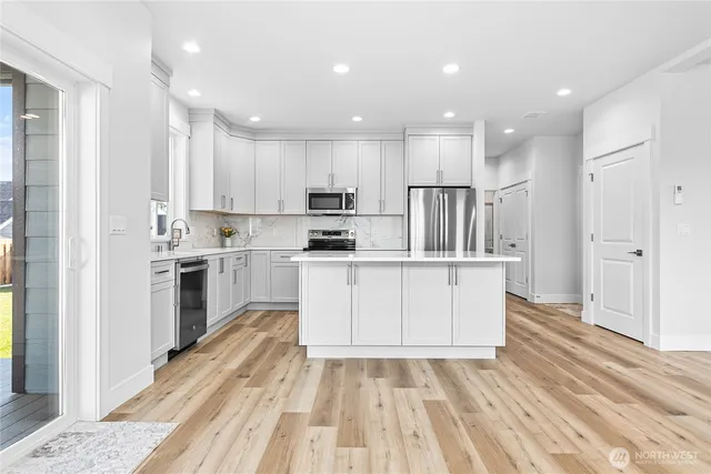 a kitchen with white cabinets stainless steel appliances and sink