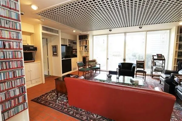 a room with furniture a bookshelf and a window