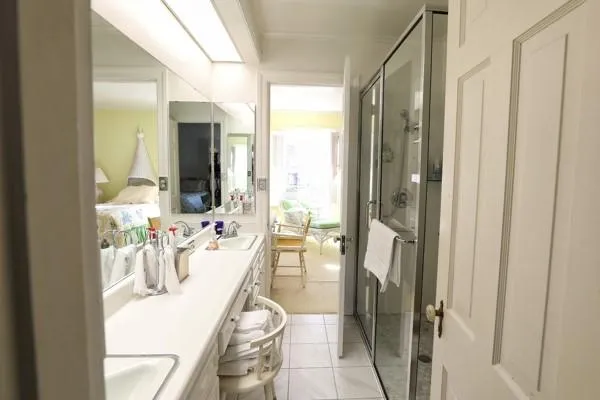 a view of a bathroom with a sink and mirror with shower