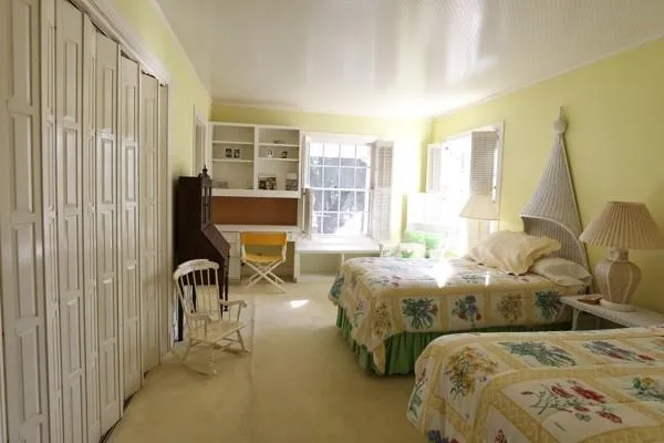 a bedroom with two beds and large windows