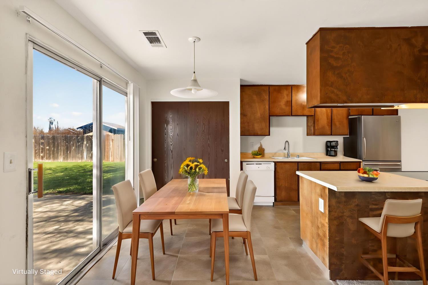 2915 Balsam Way Merced, CA 95348 - Photo 12 of 40 a kitchen with a table chairs refrigerator and cabinets