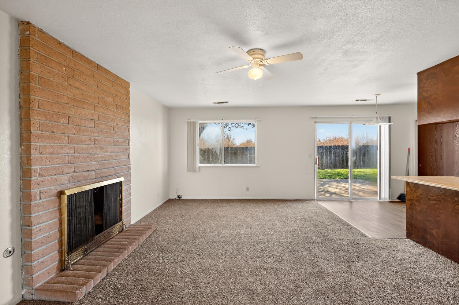 2915 Balsam Way Merced, CA 95348 - Photo 13 of 40 an empty room with windows fireplace and sink