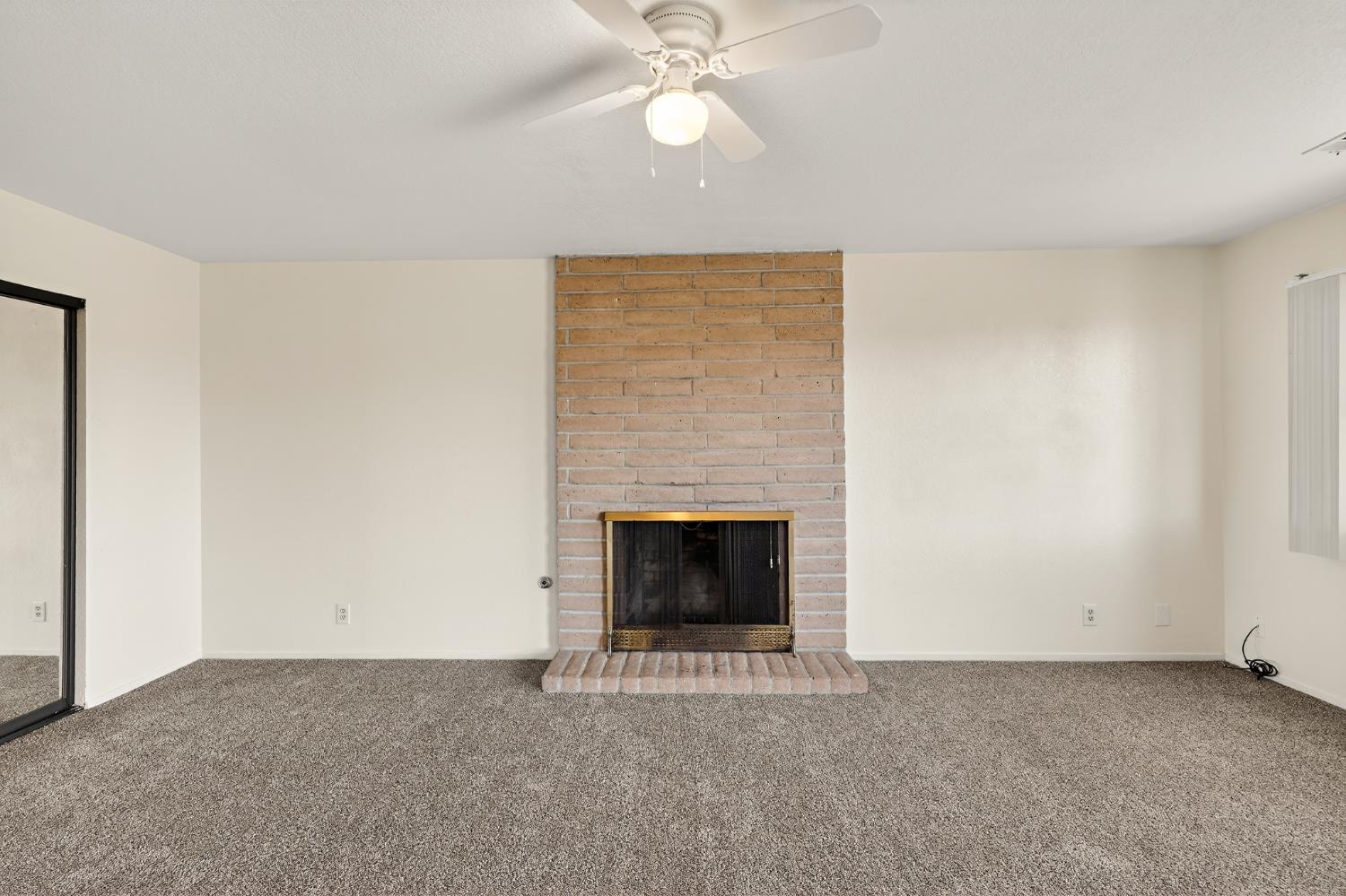 2915 Balsam Way Merced, CA 95348 - Photo 15 of 40 an empty room with fireplace and fan