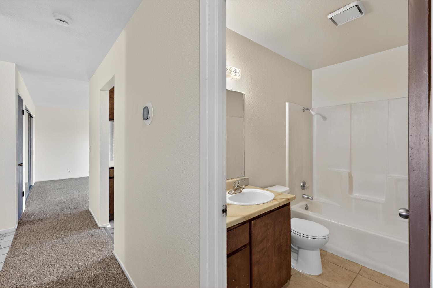 2915 Balsam Way Merced, CA 95348 - Photo 18 of 40 a bathroom with a double vanity sink toilet and shower