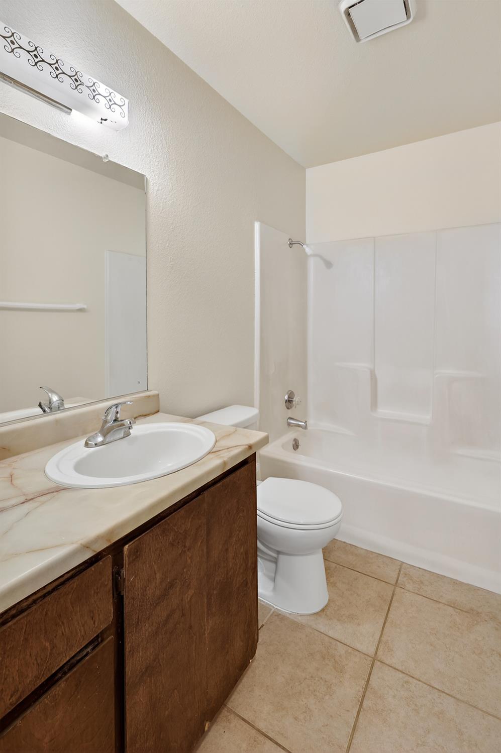 2915 Balsam Way Merced, CA 95348 - Photo 19 of 40 a bathroom with a double vanity sink toilet mirror and bathtub