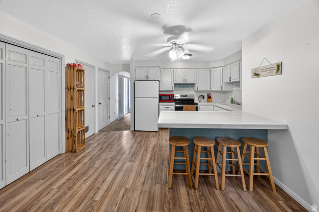 1218 East 100 South Logan, UT 84321 - Photo 5 of 23 Kitchen featuring white cabinetry, white appliances, and wood-finish flooring