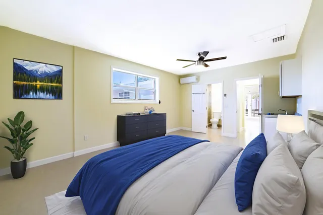 a bedroom with a large bed couch and a window