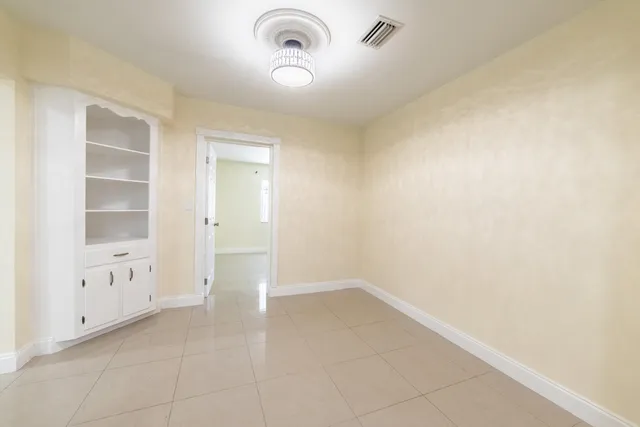 an empty room with closet and a ceiling fan