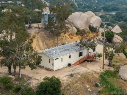 a view of a house with a yard and large trees