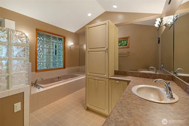 a bathroom with a tub sink and mirror