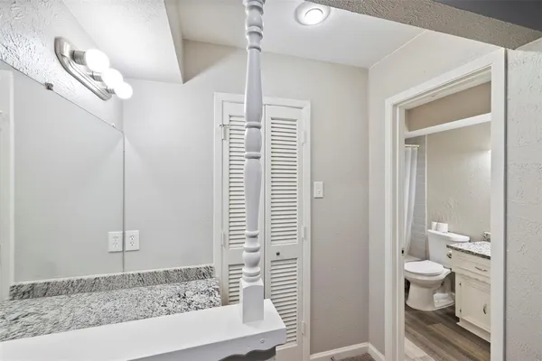 a bathroom with a granite countertop sink a toilet and shower