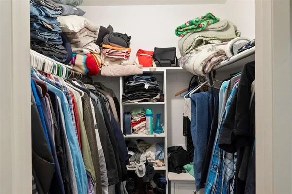 a view of walk in closet with clothes and shoes