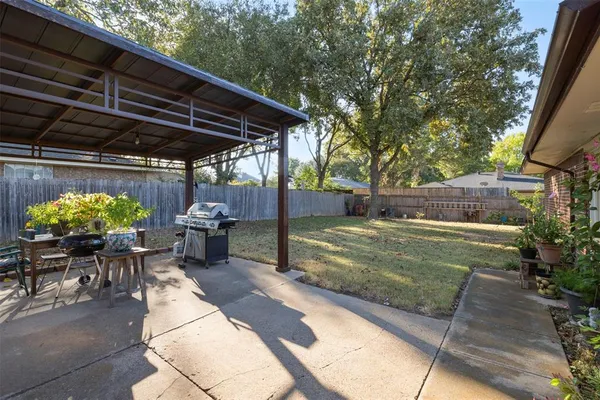 a view of a backyard with table and chairs under an umbrella