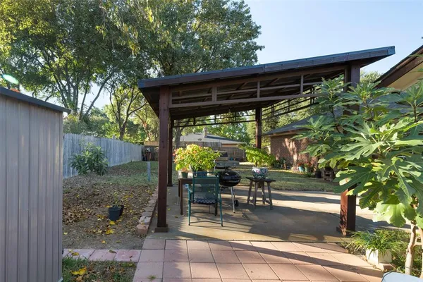 a view of a patio with table and chairs potted plants with wooden floor and fence