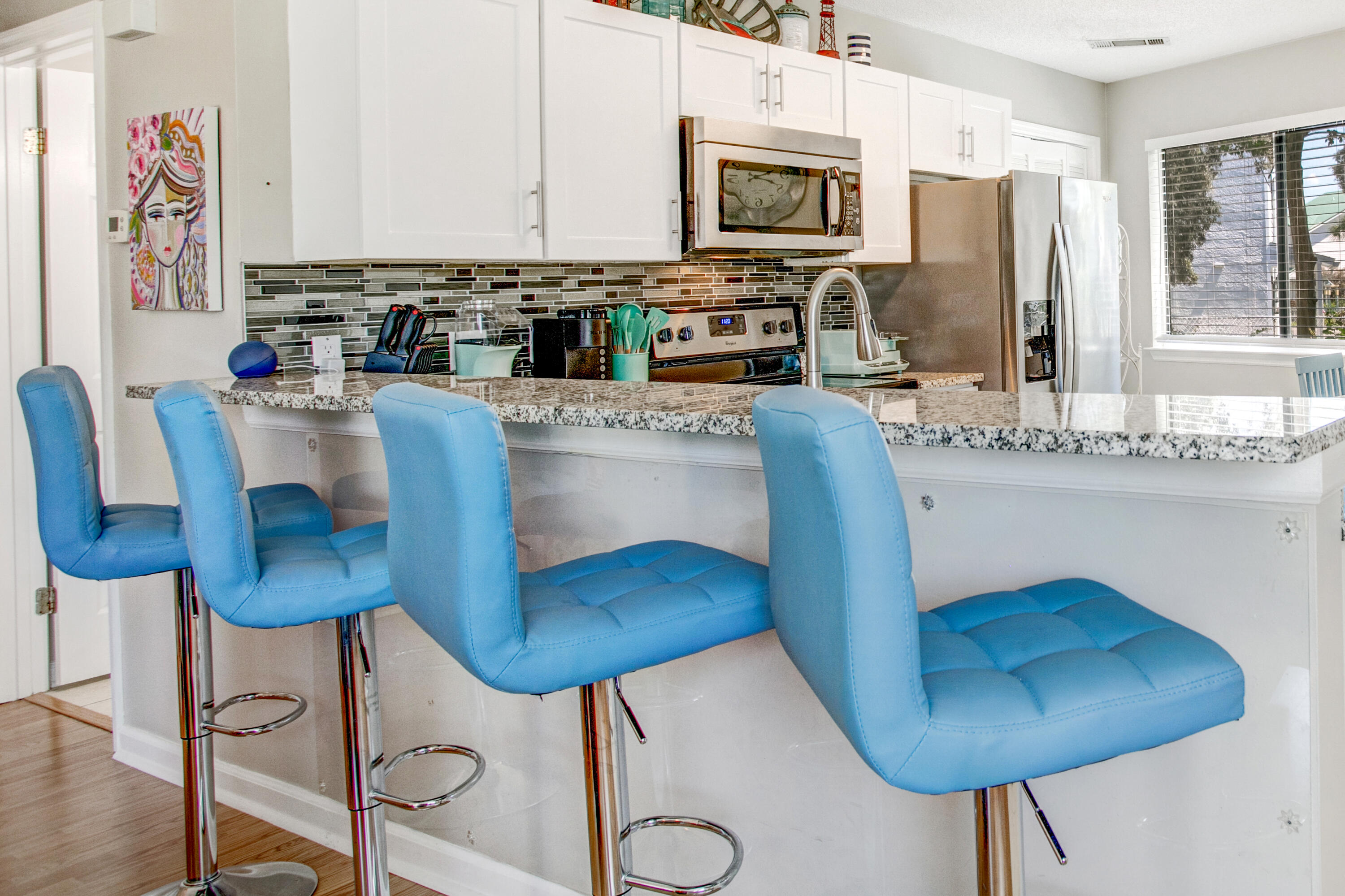 285 Payne Street, Unit 5A Miramar Beach, FL 32550 - Photo 1 of 20 a kitchen with stainless steel appliances kitchen island granite countertop a table chairs and a refrigerator