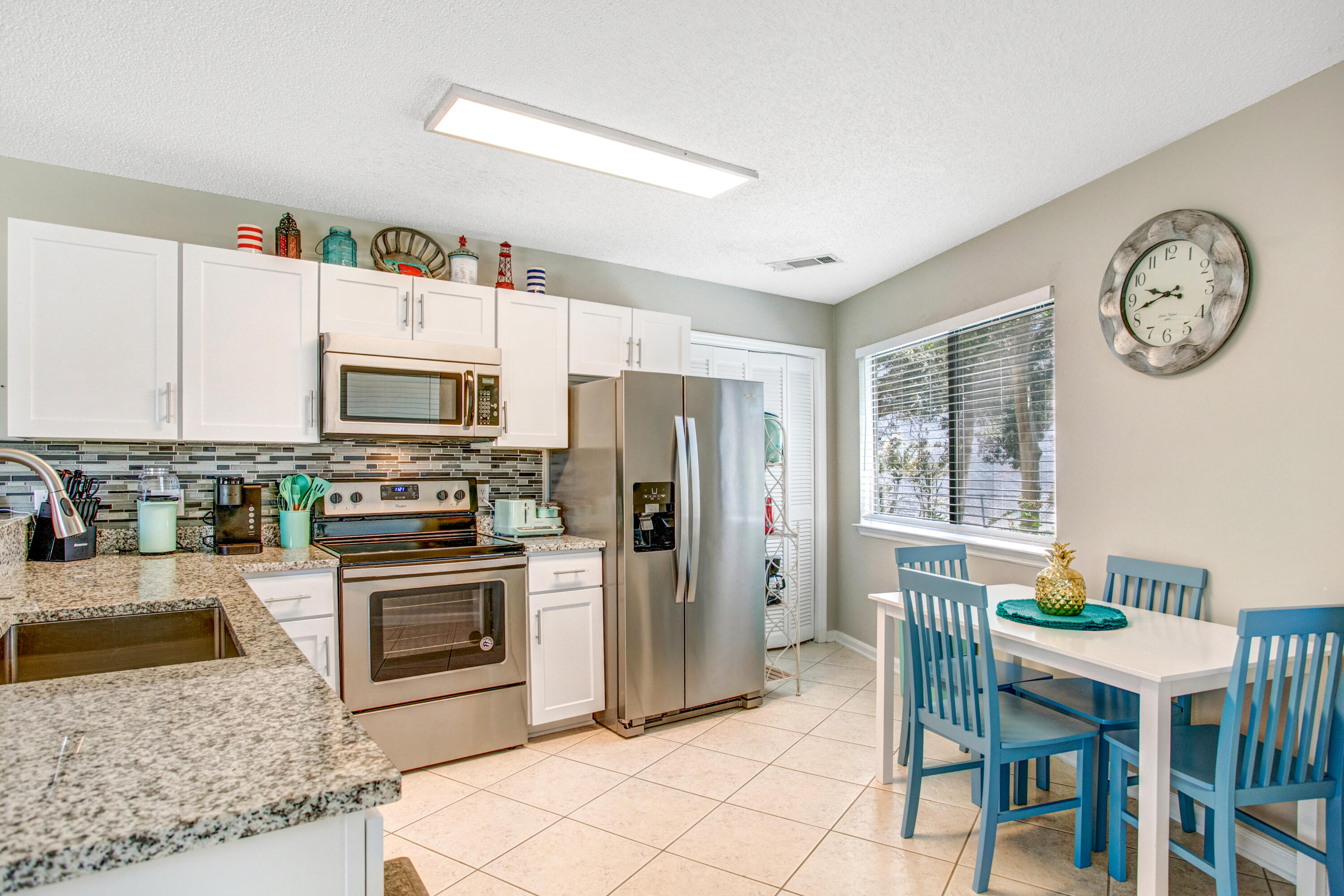 285 Payne Street, Unit 5A Miramar Beach, FL 32550 - Photo 2 of 20 a kitchen with stainless steel appliances granite countertop a stove a refrigerator a kitchen island a dining table and chairs