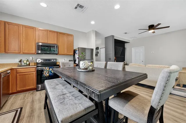 a kitchen with a table chairs microwave and cabinets