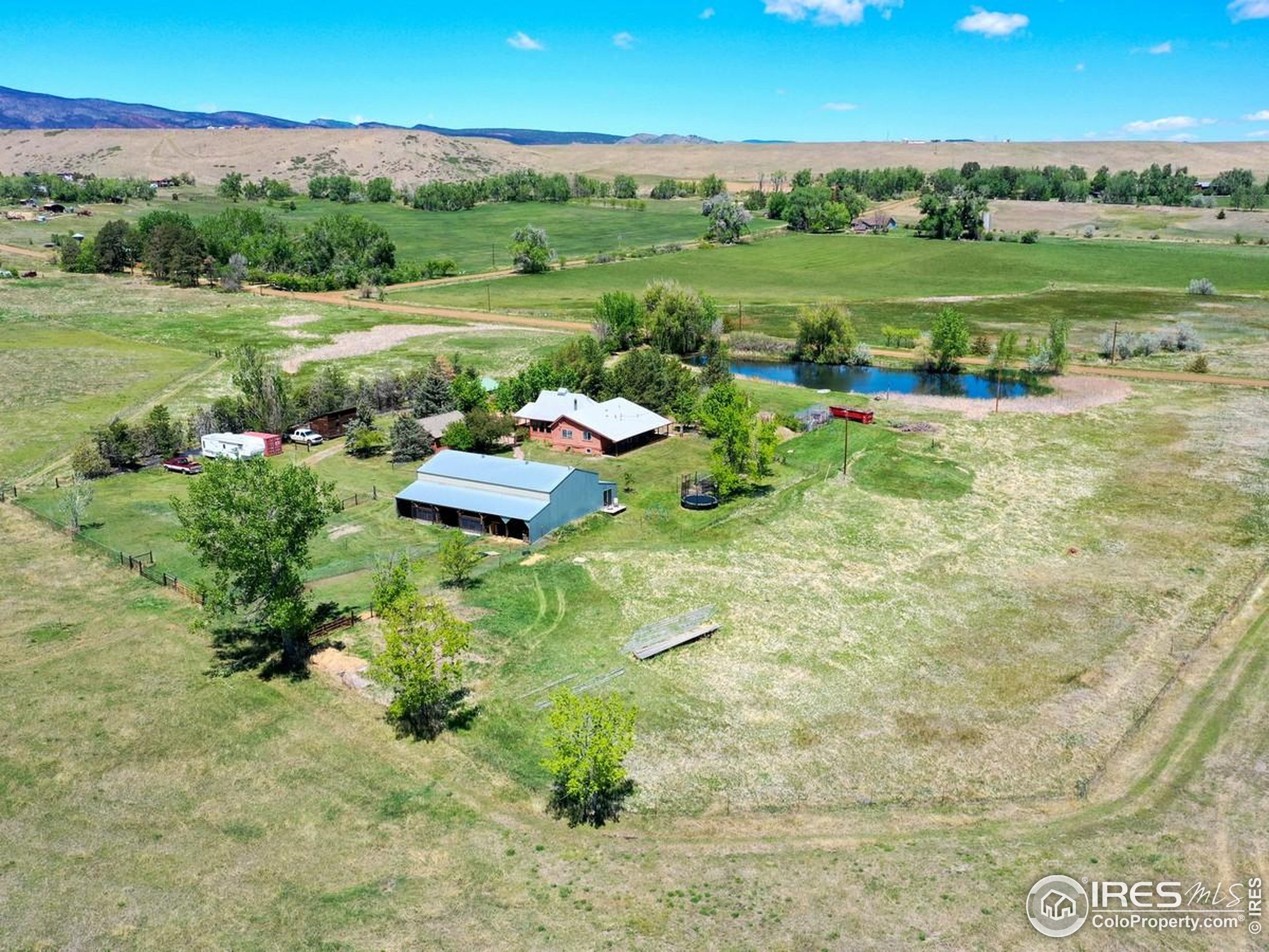 5196 Oxford Road Longmont, CO 80503 - Photo 12 of 38 a view of a lake with a yard and large trees