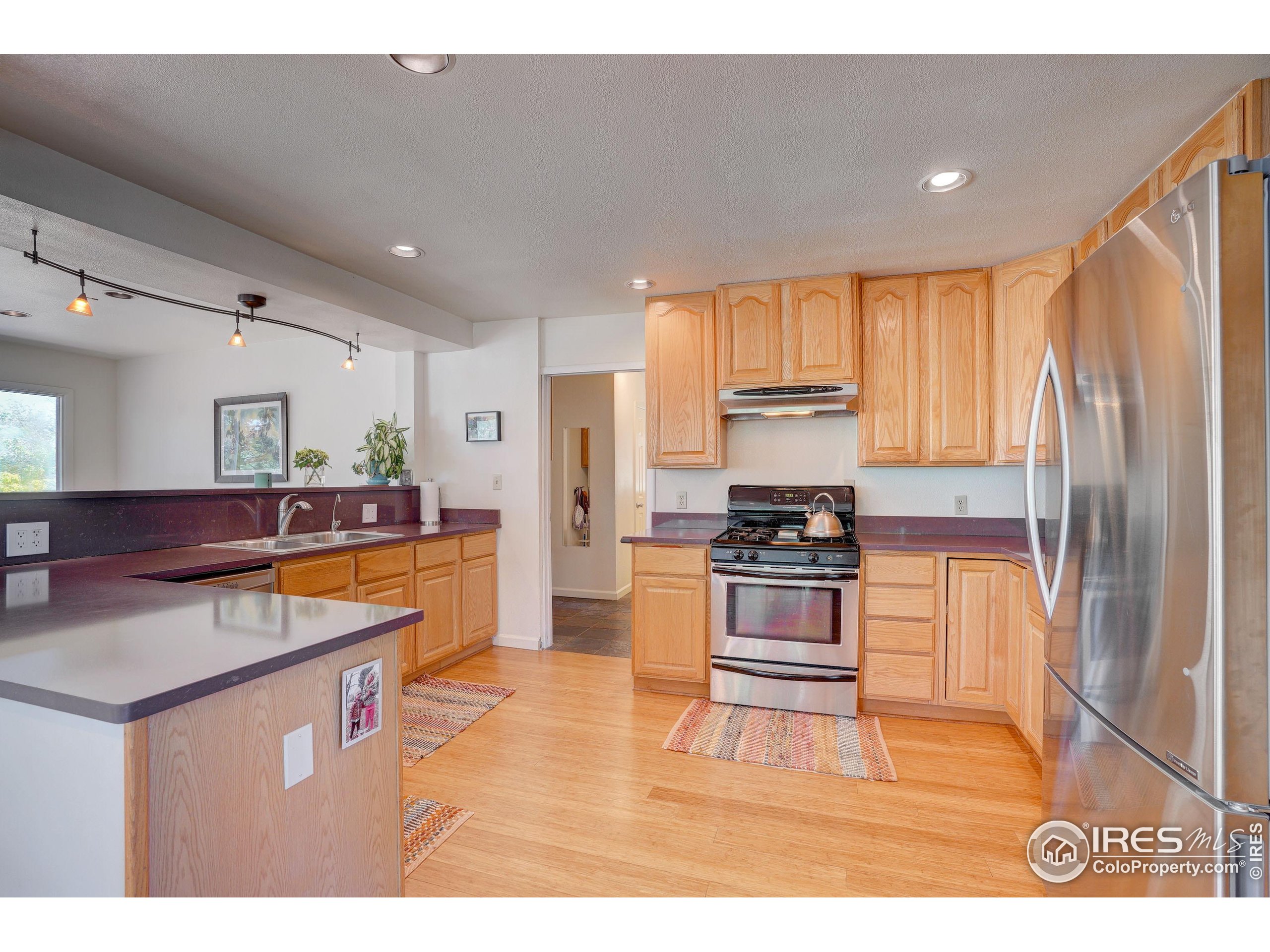 5196 Oxford Road Longmont, CO 80503 - Photo 22 of 38 a kitchen with stainless steel appliances granite countertop a sink stove and refrigerator