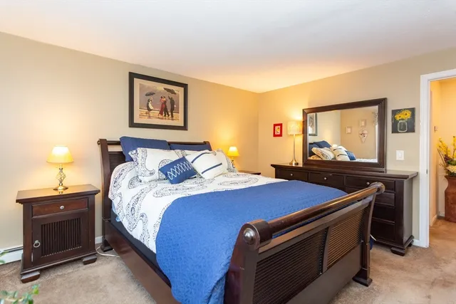 a bedroom with bed and paintings on the wall