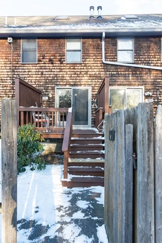 a view of a patio with table and chairs with wooden floor and fence
