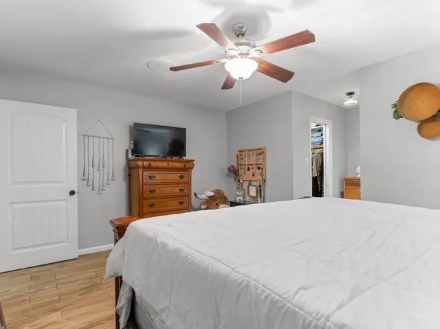 a bedroom with a bed and a flat tv screen on dresser