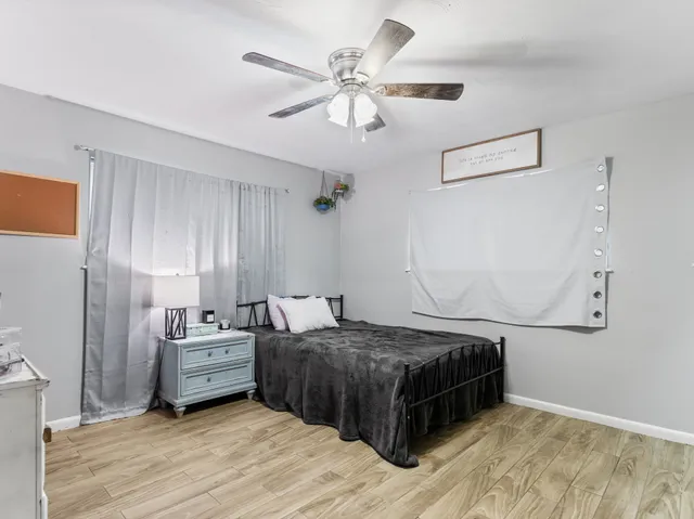 a bedroom with a bed and a ceiling fan