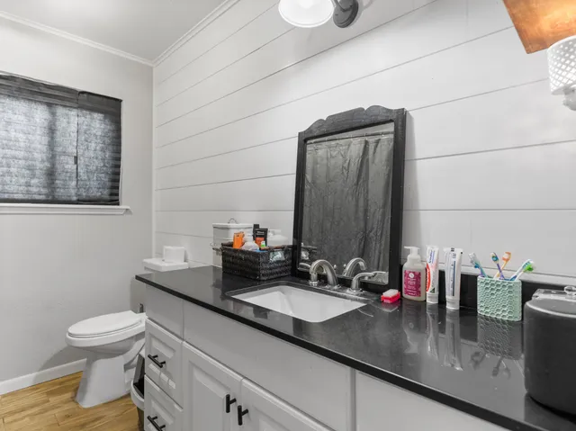 a bathroom with a sink a toilet and mirror