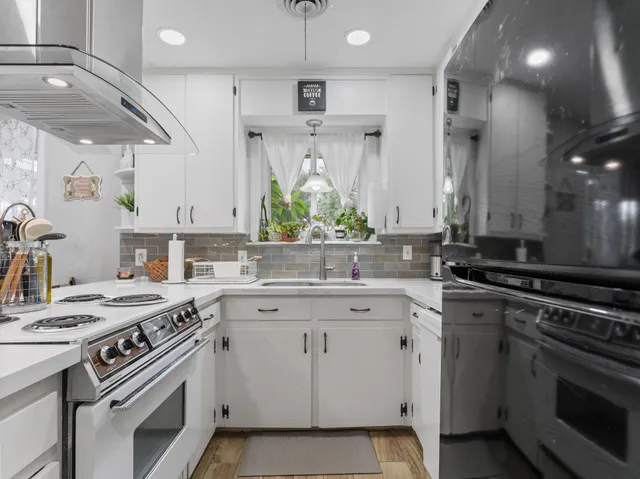 a kitchen with white cabinets and appliances