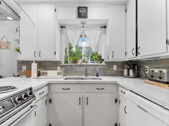 a kitchen with stainless steel appliances granite countertop a sink stove and cabinets