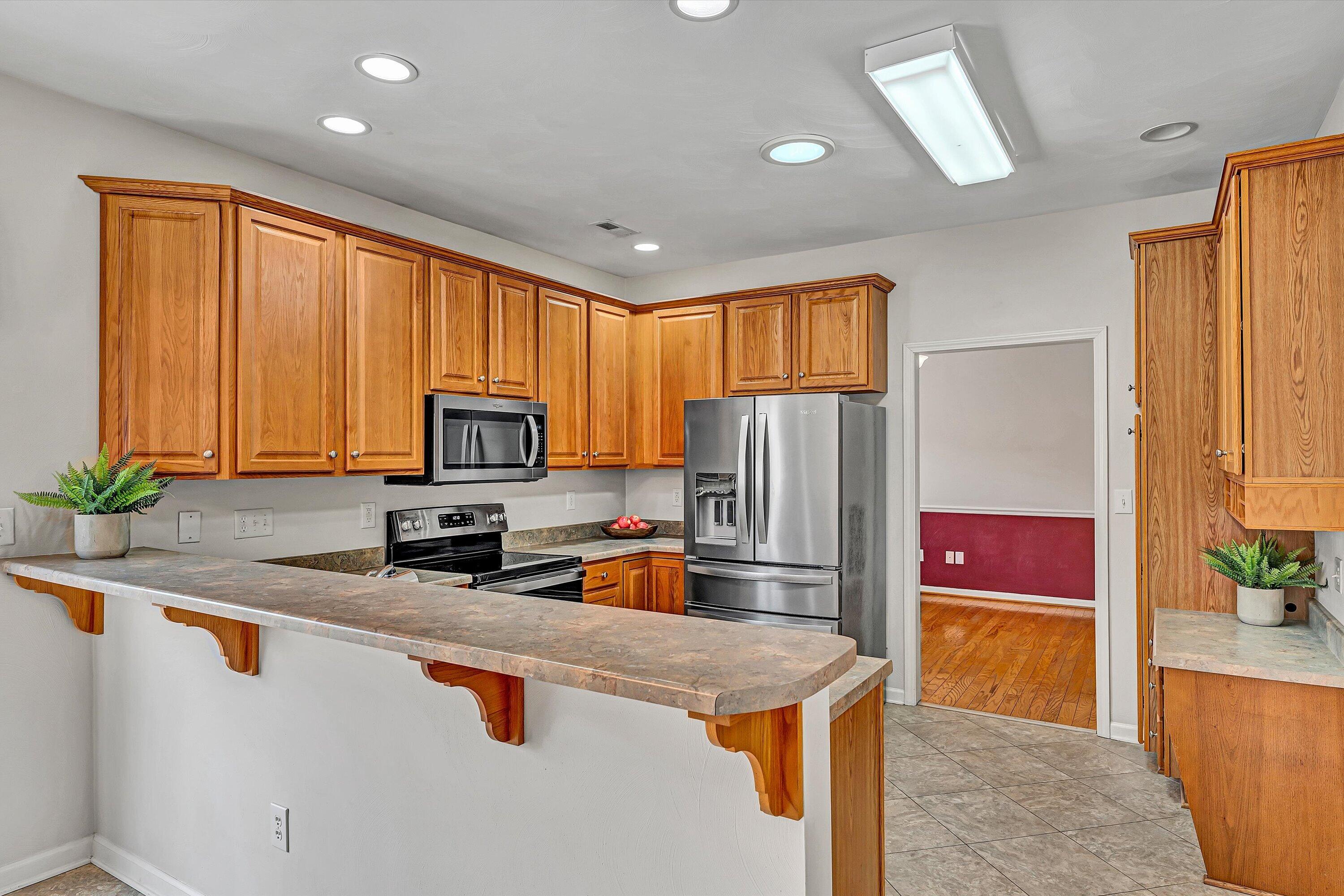 1365 Aarons Run Circle Salem, VA 24153 - Photo 15 of 35 a kitchen with granite countertop a refrigerator a stove a sink a counter space and cabinets