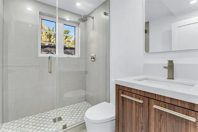 a bathroom with a sink a toilet and shower