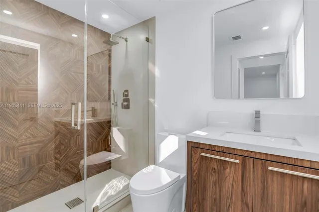 a bathroom with a granite countertop sink toilet and shower