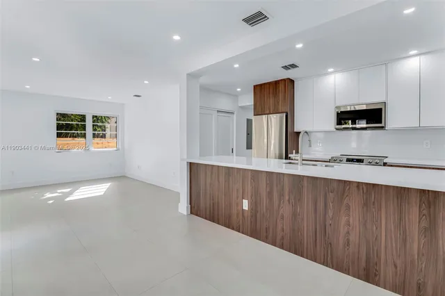 a kitchen with stainless steel appliances a refrigerator sink and microwave