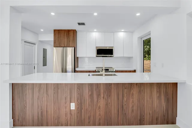 a large kitchen with a large window and stainless steel appliances